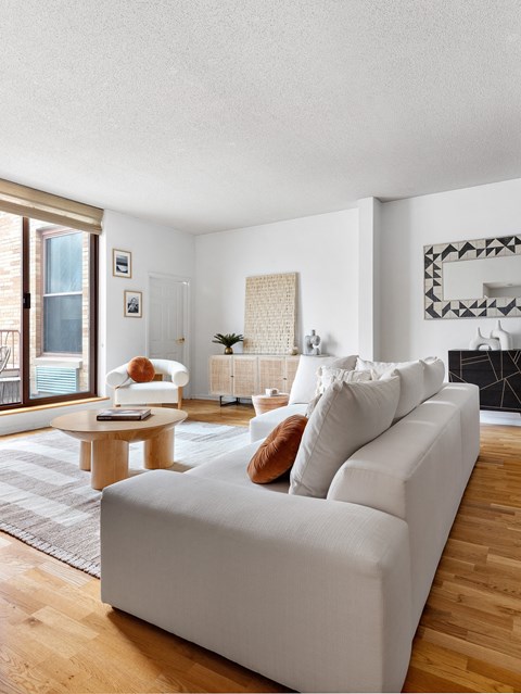 a living room with a white couch and a wood floor